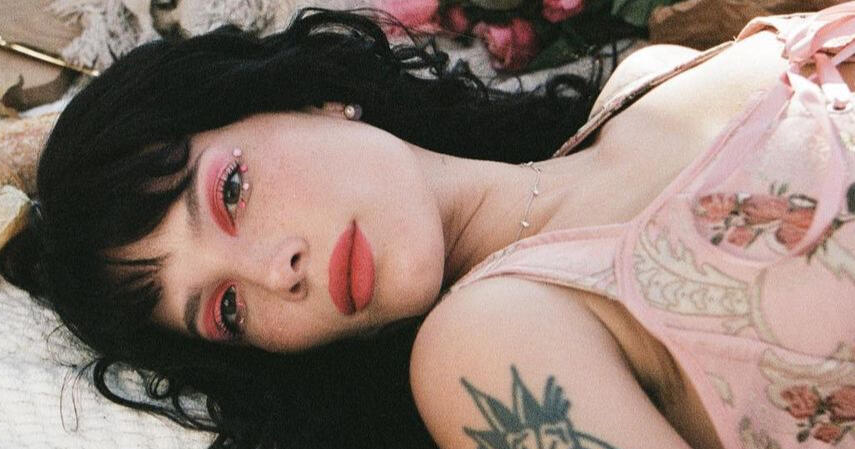 Halsey laying down on a blanket with pink eyeshadow for an about-face ad